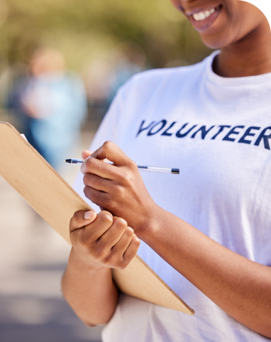 Volunteer writing on clipboard outdoors.