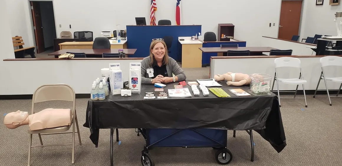 Woman at health fair information table.