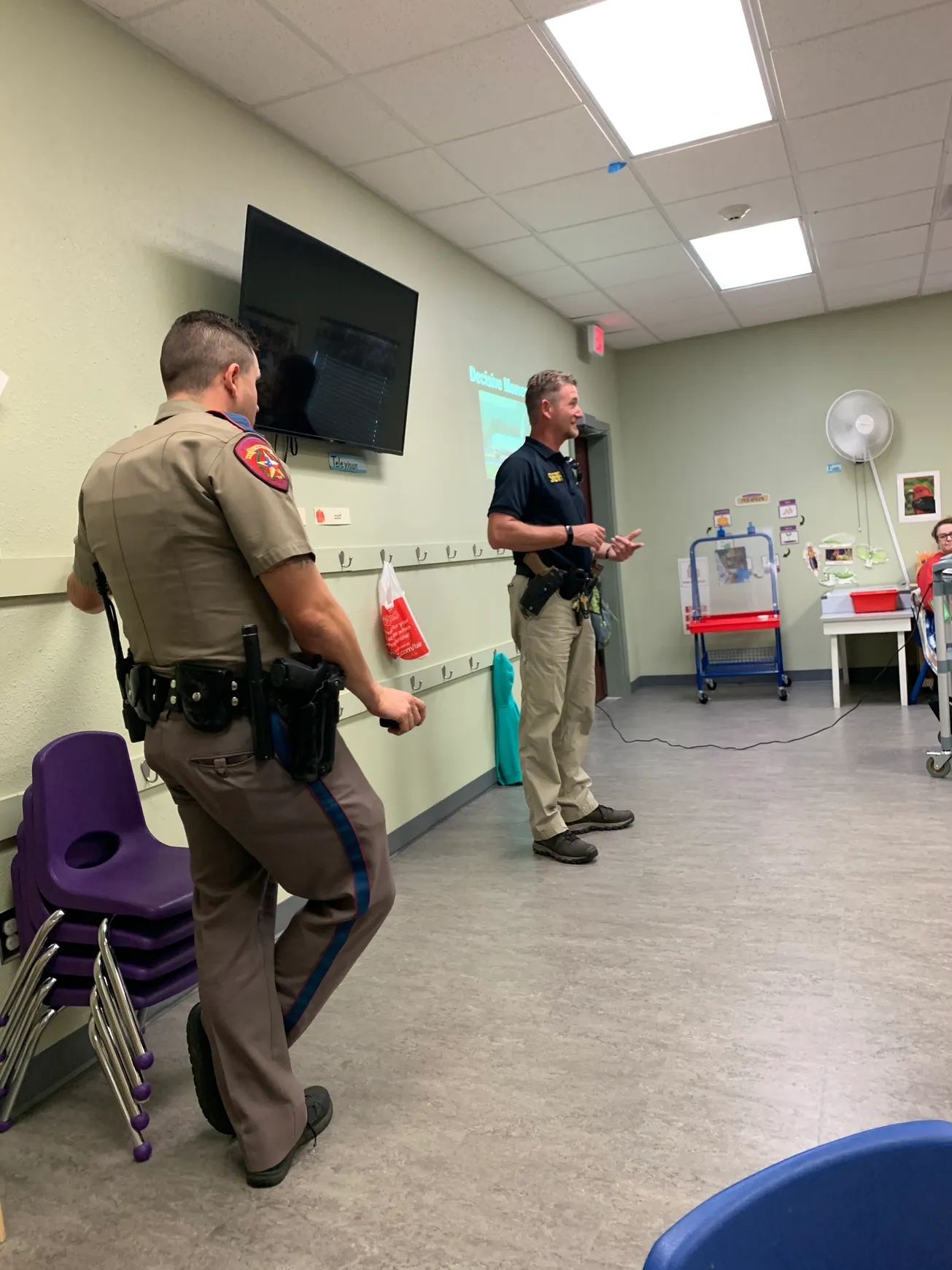 Police officer giving presentation to children.