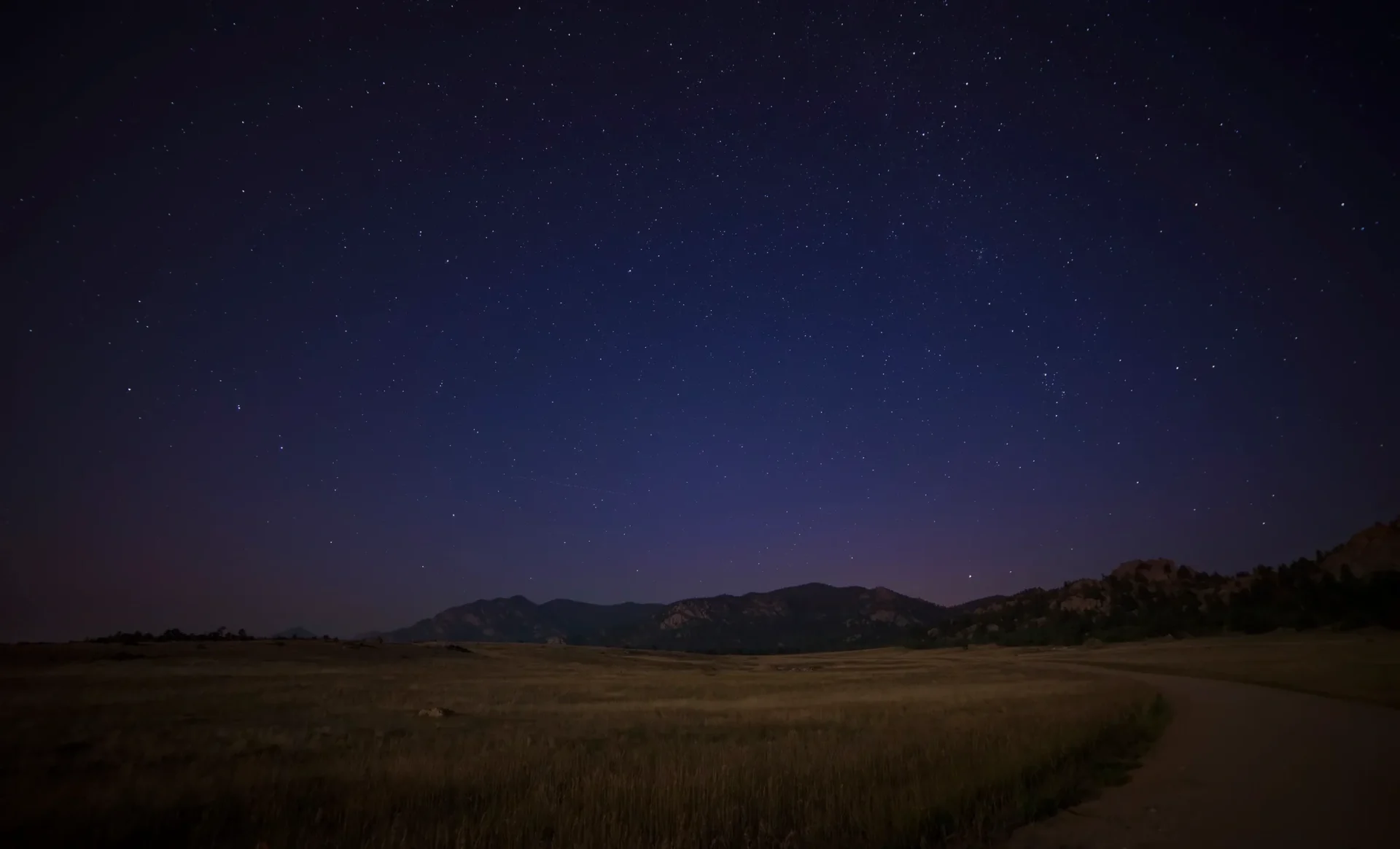 Starry night over mountain field.